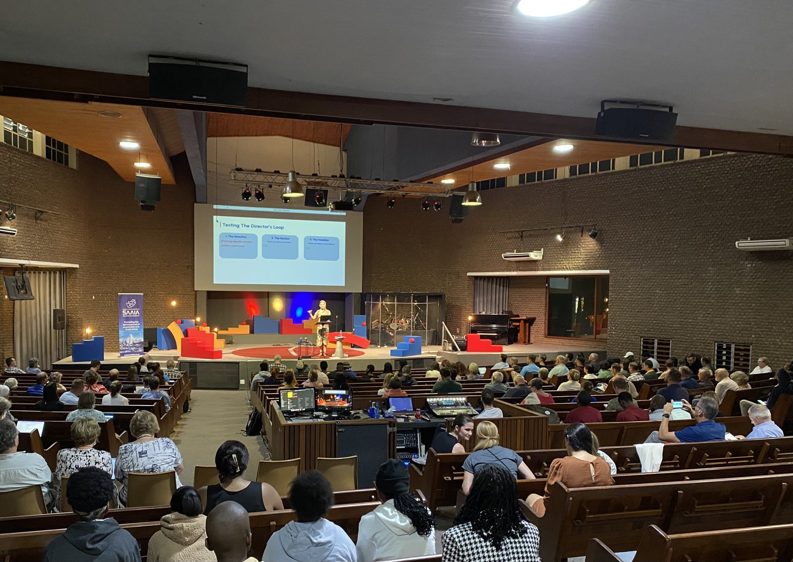Lucy Calcott speaking on stage to a full auditorium at a policymaker conference in South Africa